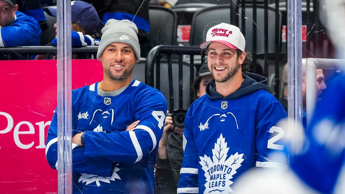 George Springer and Ernie Clement sitting together watching Toronto Maple Leafs warmups at Scotiabank Arena