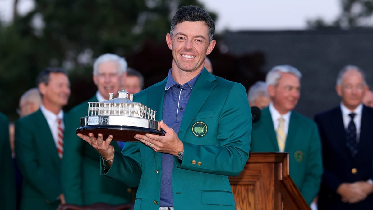 Rory McIlroy holding the Masters trophy and wearing the green jacket at Augusta National