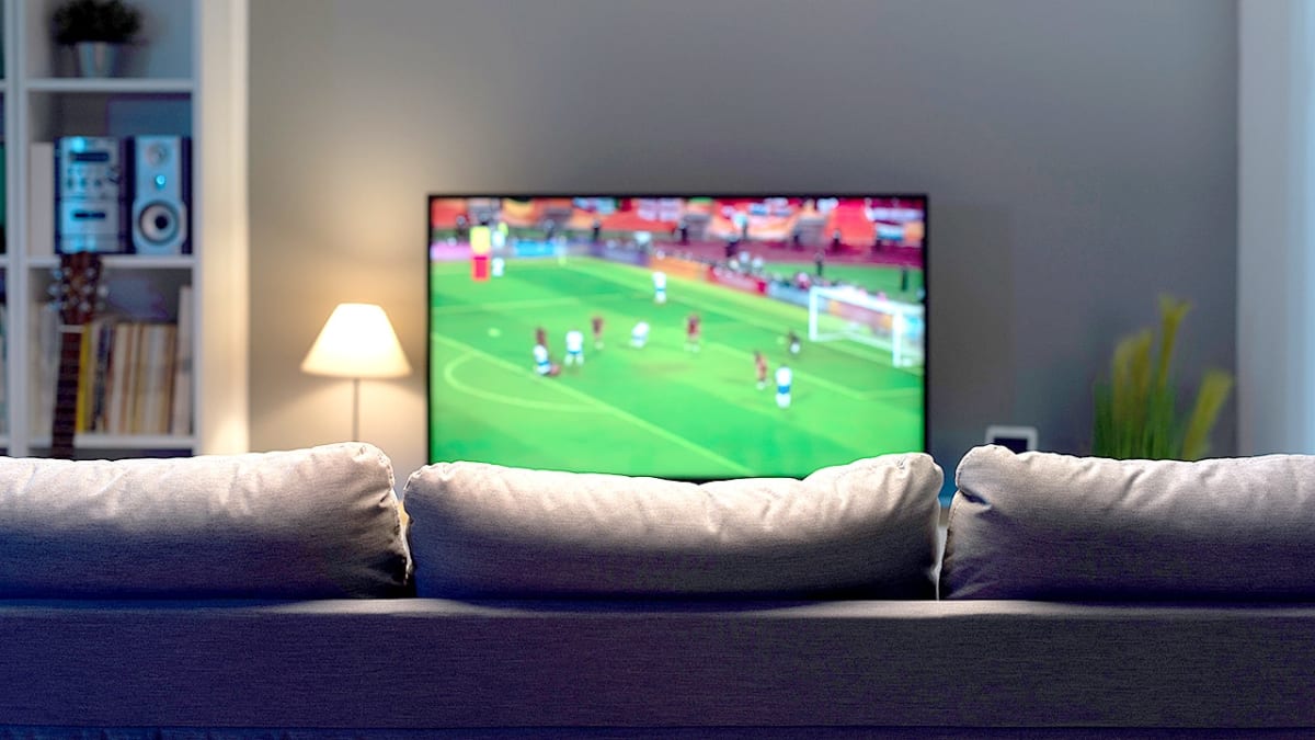 Modern flat screen television displaying a soccer match in home living room setting