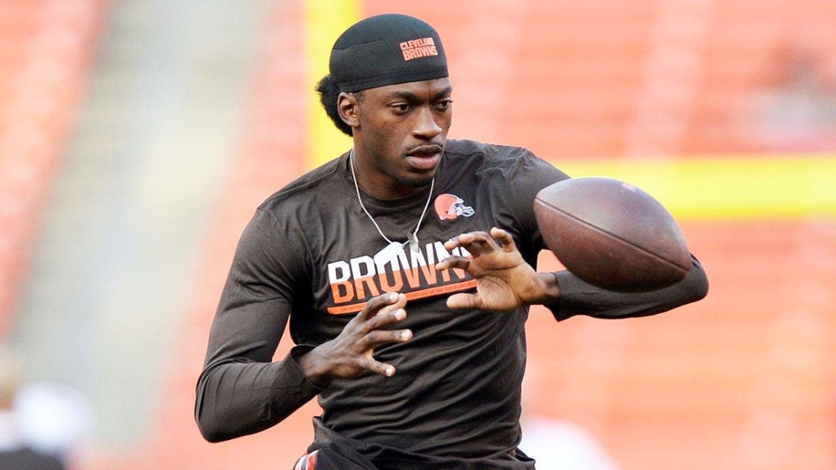 Robert Griffin III in ESPN analyst role on football field sideline looking determined