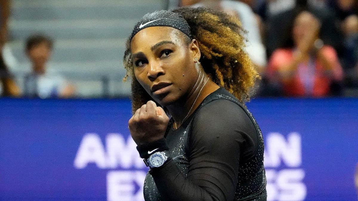 Serena Williams holding tennis racket on grass court at professional tournament