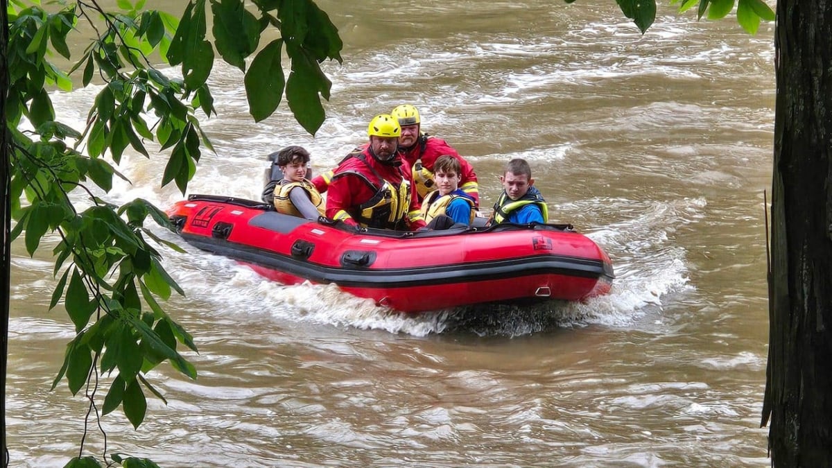 Emergency rescue crews with watercraft assisting Boy Scouts stranded along flooded Cacapon River