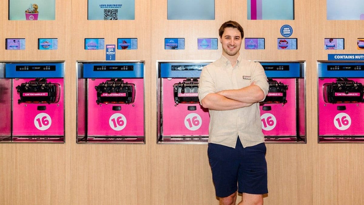 Young entrepreneur Neil Hershman standing inside a 16 Handles frozen yogurt shop location