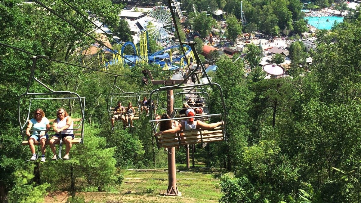 Historic Knoebels Amusement Resort entrance with tree-lined walkways and classic rides in Pennsylvania