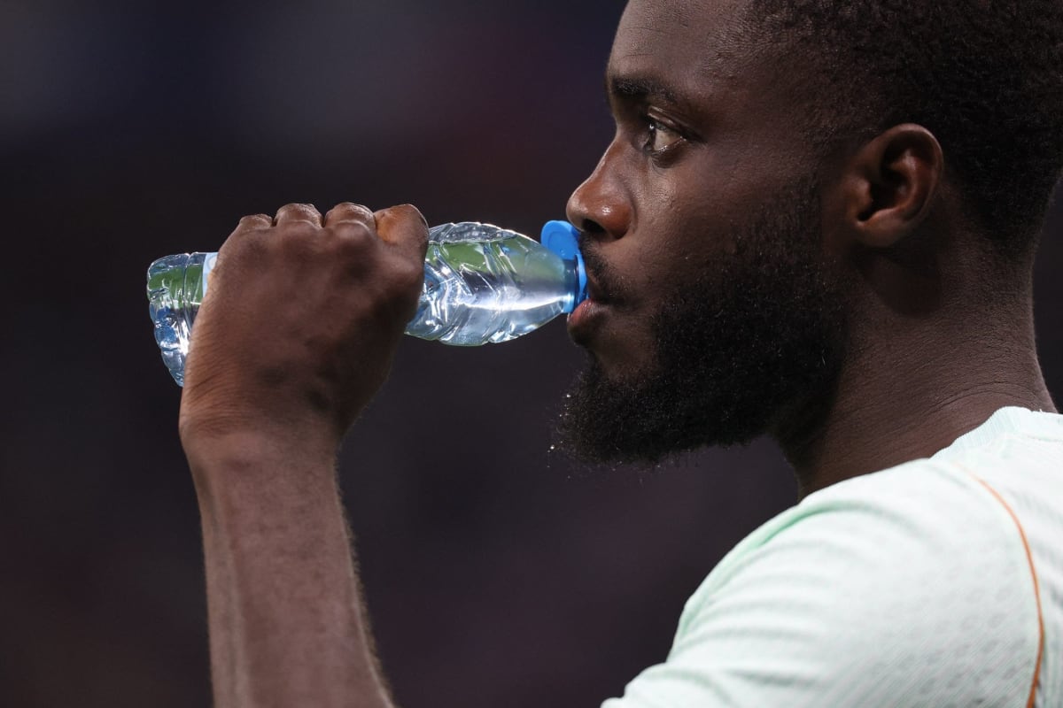 Soccer players taking water break during 2026 FIFA World Cup match with coaches nearby