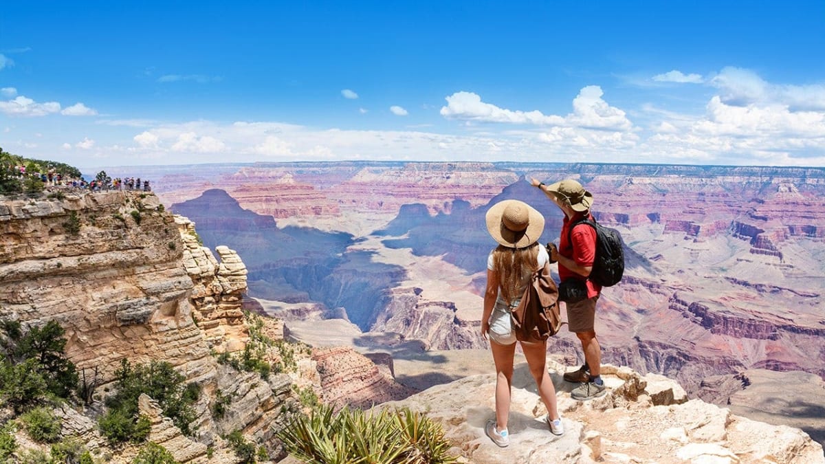 Hikers walking through scenic national park trail surrounded by mountains and greenery