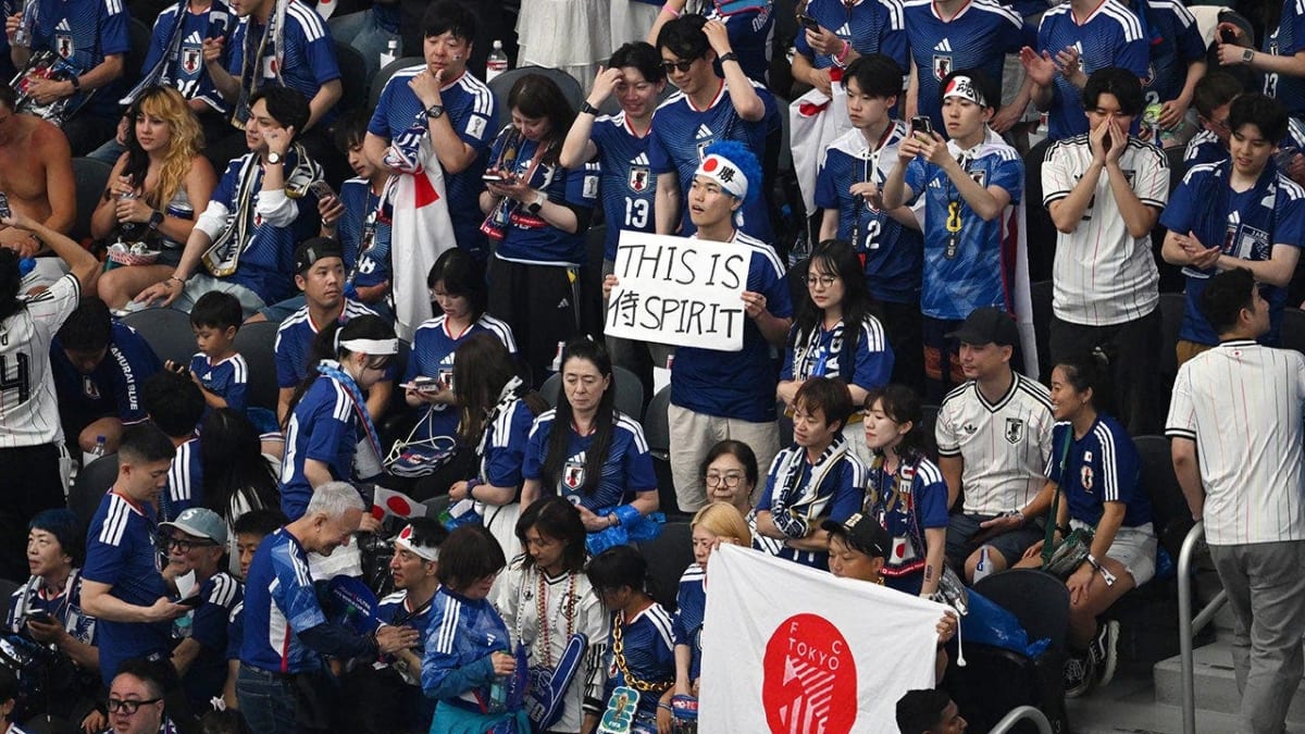 Japanese World Cup fans holding trash bags while cleaning stadium seats in Dallas