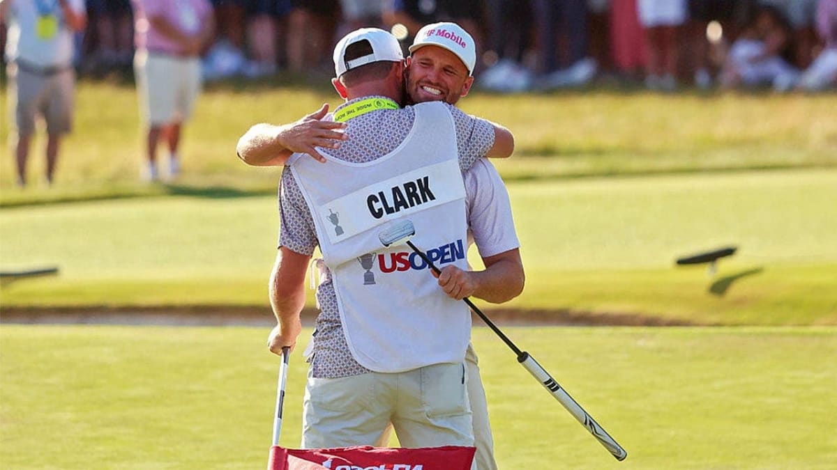 Wyndham Clark celebrating with his caddie on the 18th green at Shinnecock Hills Golf Club
