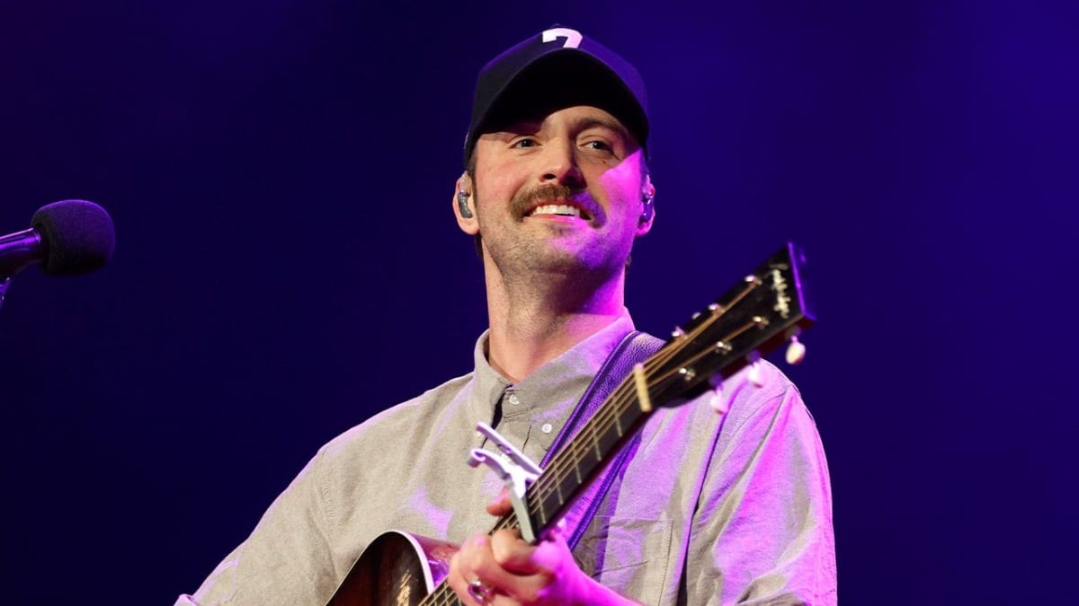 Country singer Ruston Kelly holding gold Narcotics Anonymous recovery token celebrating sobriety milestone