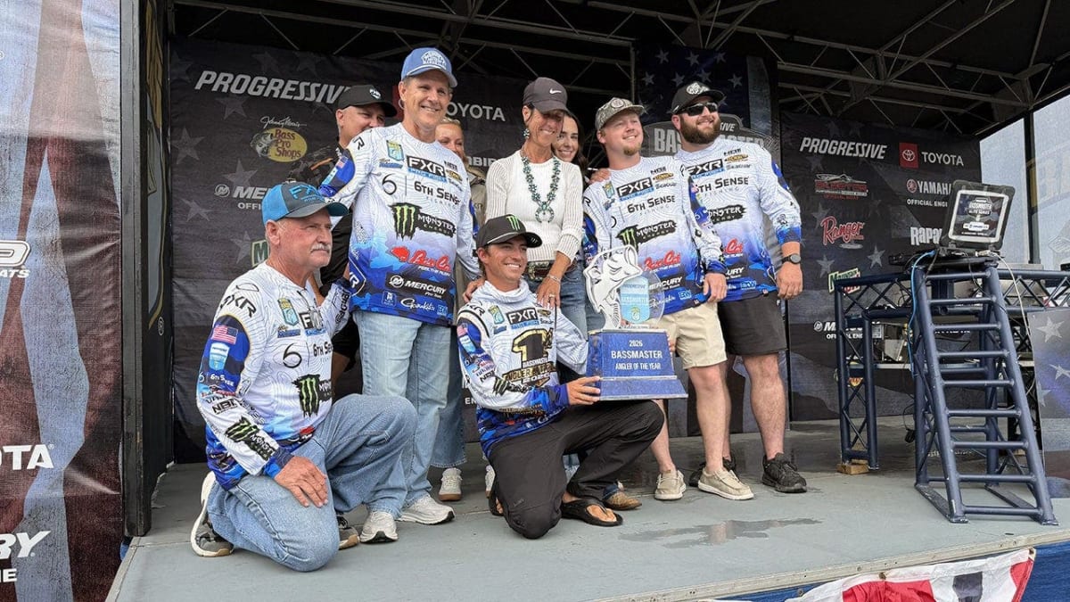 Young fisherman Trey McKinney celebrates holding Bassmaster Angler of Year trophy surrounded by supporters