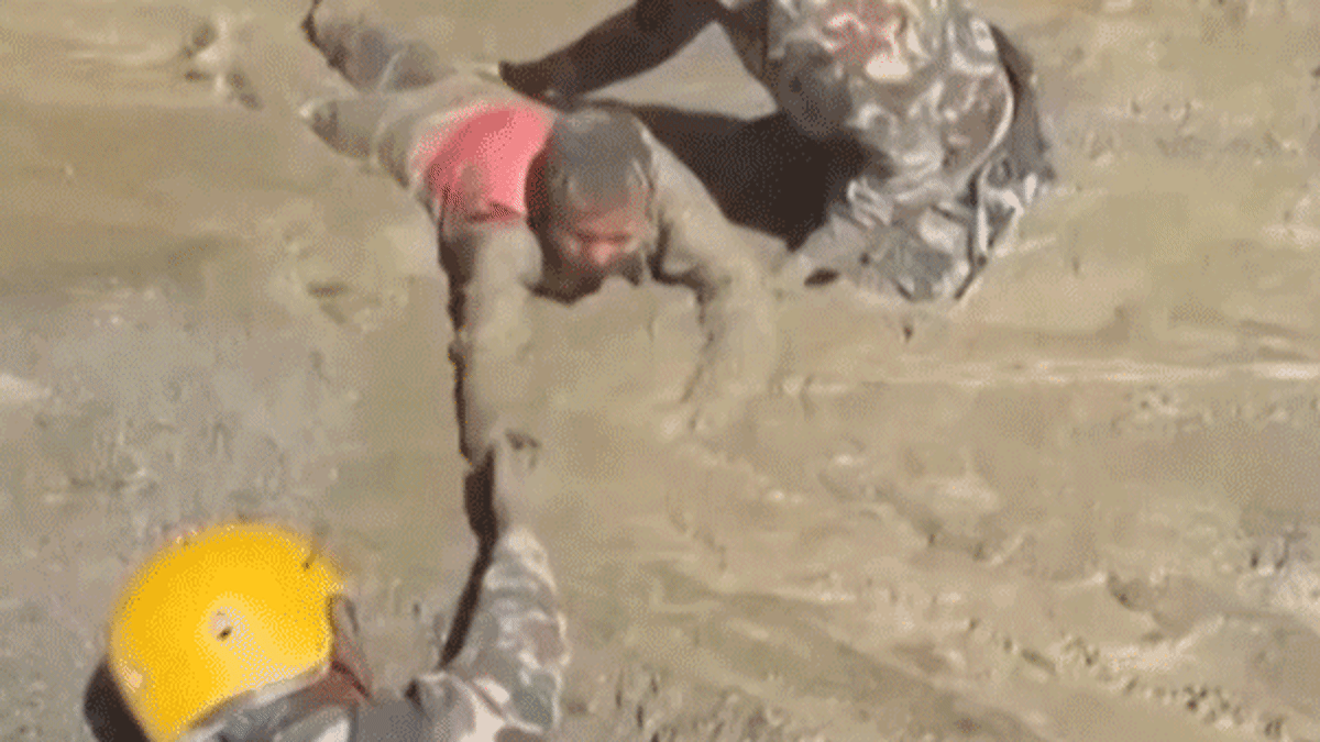 Rescue workers pulling trapped person through muddy hydropower tunnel in Nepal