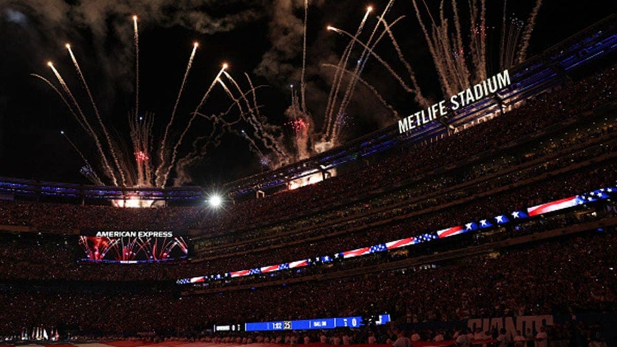 ** New York Giants players holding massive American flag on field during 9/11 tribute ceremony