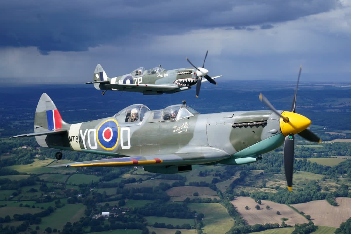Two-seat Spitfire aircraft painted in historic K5054 prototype livery flying over British countryside