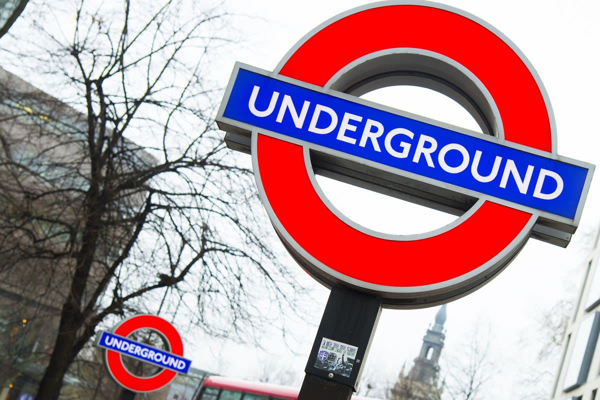 London Underground train at platform station with commuters waiting on platform