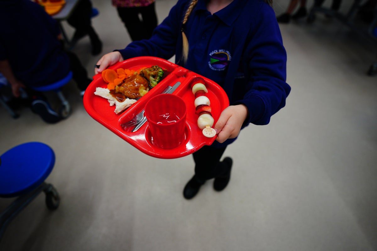 Young students eating lunch together in a school cafeteria, smiling and enjoying their meals