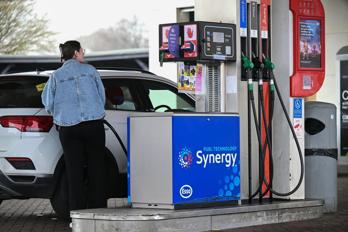 Driver filling up car with petrol at UK gas station forecourt pump