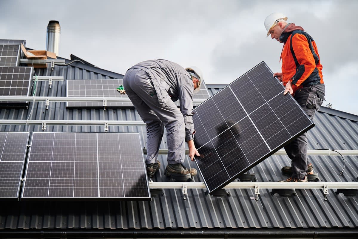 Solar panels installed on residential British home roof under partly cloudy sky