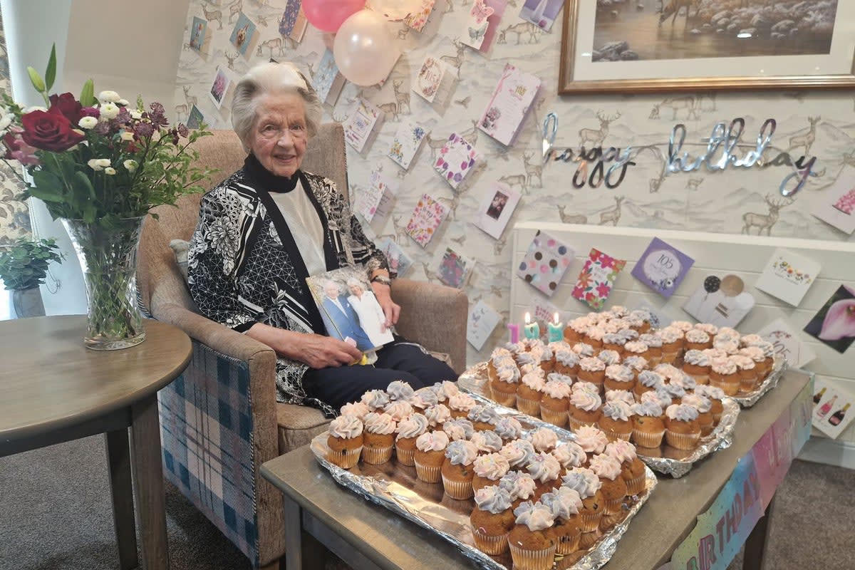 Mary Davidson Smith smiling at her 105th birthday celebration surrounded by cards