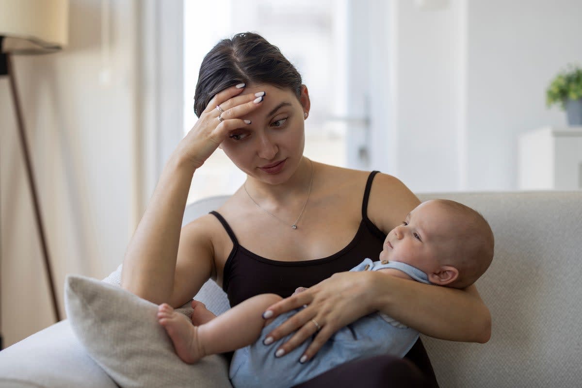 New mother holding baby while receiving compassionate care from healthcare provider in hospital setting