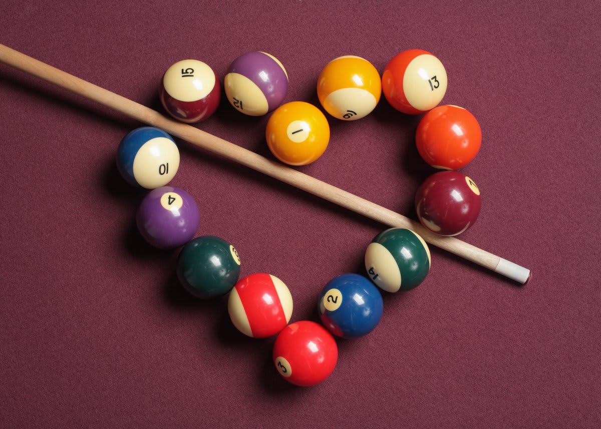 Colorful billiard balls arranged on geometric polygon-shaped table illustrating mathematical trajectory concept