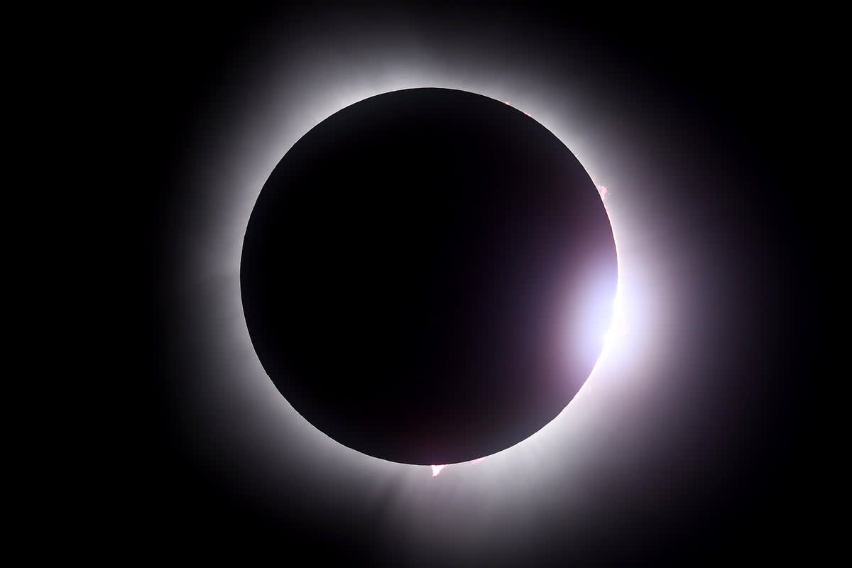 NASA research jet flying at high altitude with sun's corona visible during total solar eclipse