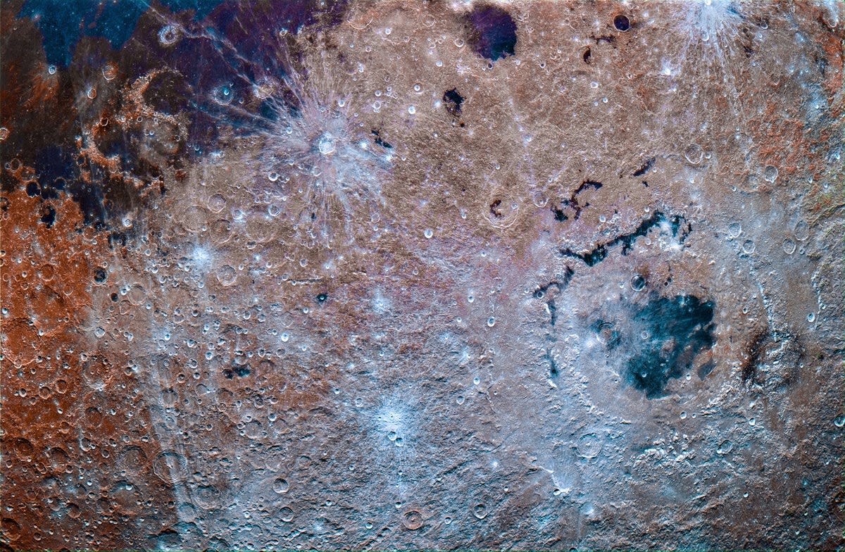 ** Color-enhanced photograph of moon's far side showing orange iron oxide and blue titanium deposits