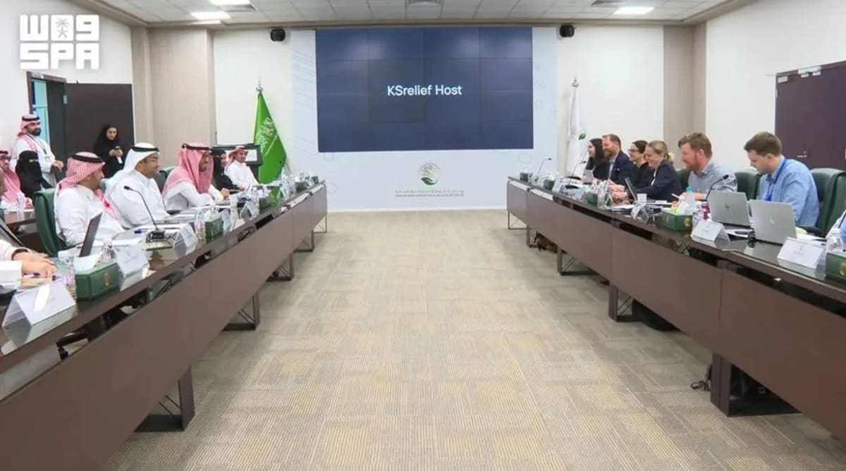 Modern conference room with humanitarian aid and artificial intelligence experts collaborating on laptop screens