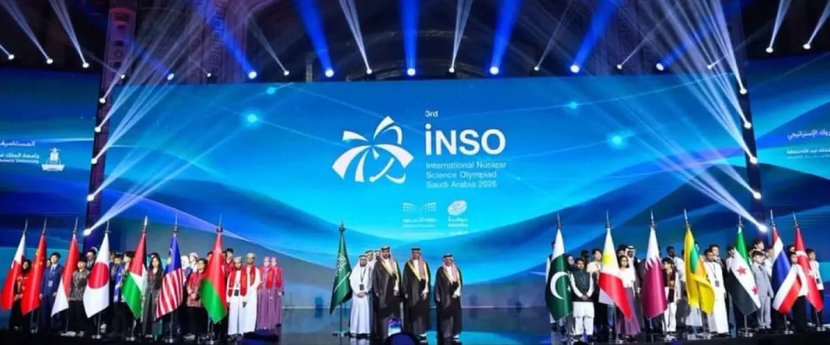 Young students in lab coats conducting nuclear science experiments at international competition in Jeddah