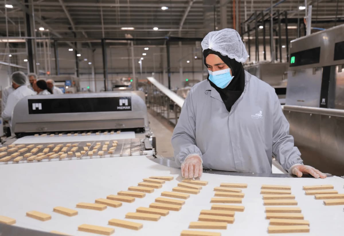 Modern factory production line with workers manufacturing biscuits and chocolate products in Morocco