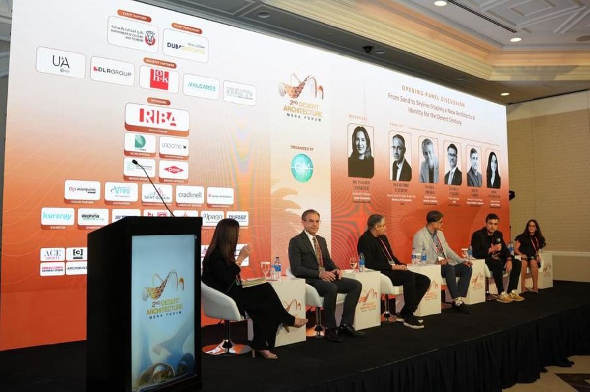 ** Architects and urban planners discussing sustainable desert architecture at Dubai forum conference