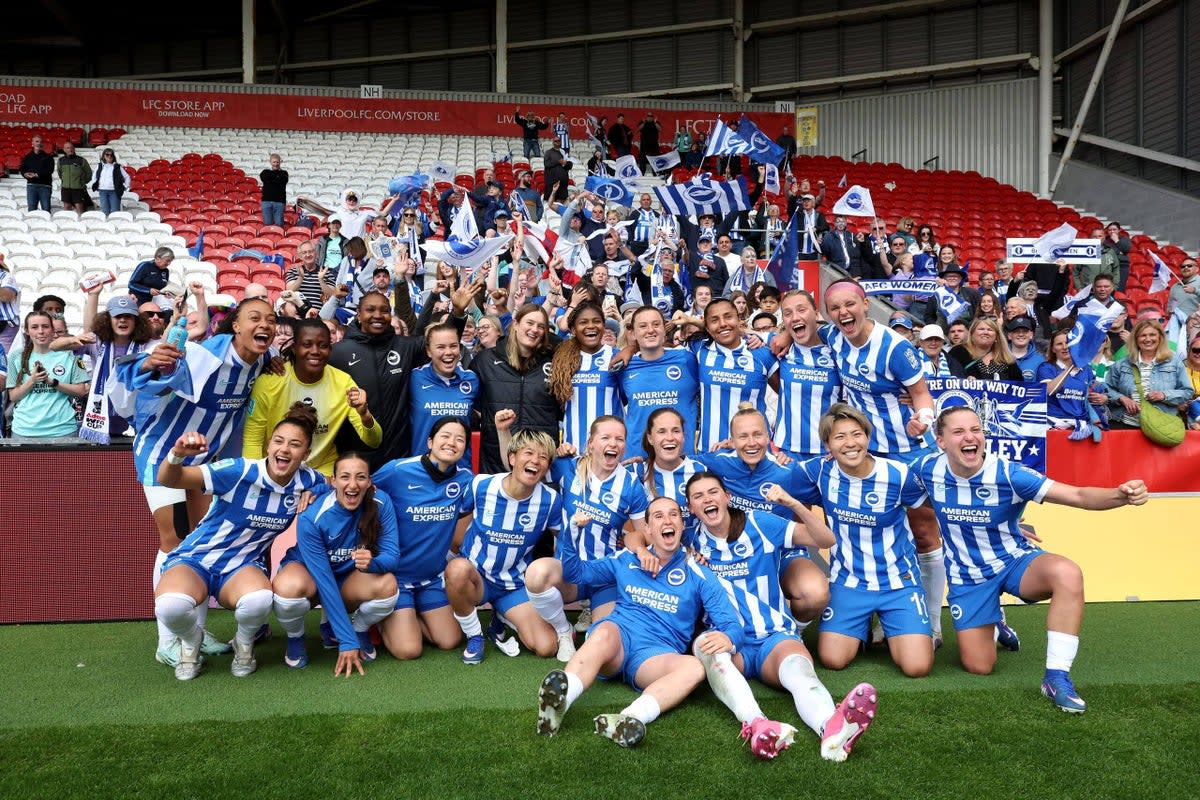 Brighton women's football players celebrate together on the pitch after reaching FA Cup final