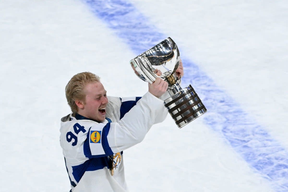 Finnish hockey players celebrating gold medal victory on ice after overtime goal