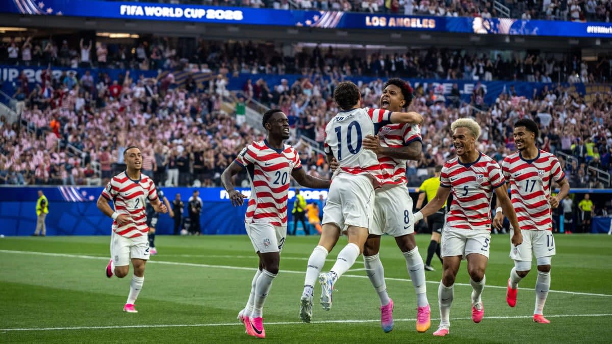 U.S. soccer players celebrate together in red uniforms during World Cup victory over Paraguay