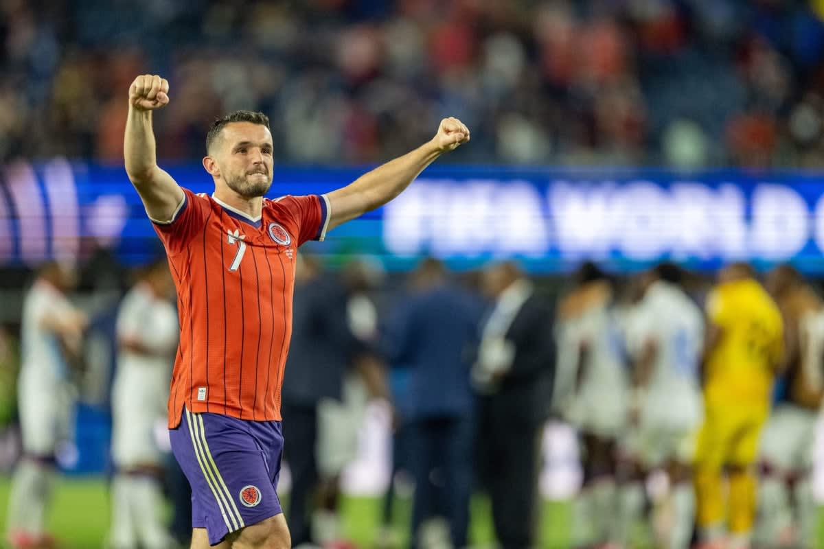 ** Scottish football fans celebrating wildly in stadium seats waving flags after historic World Cup victory