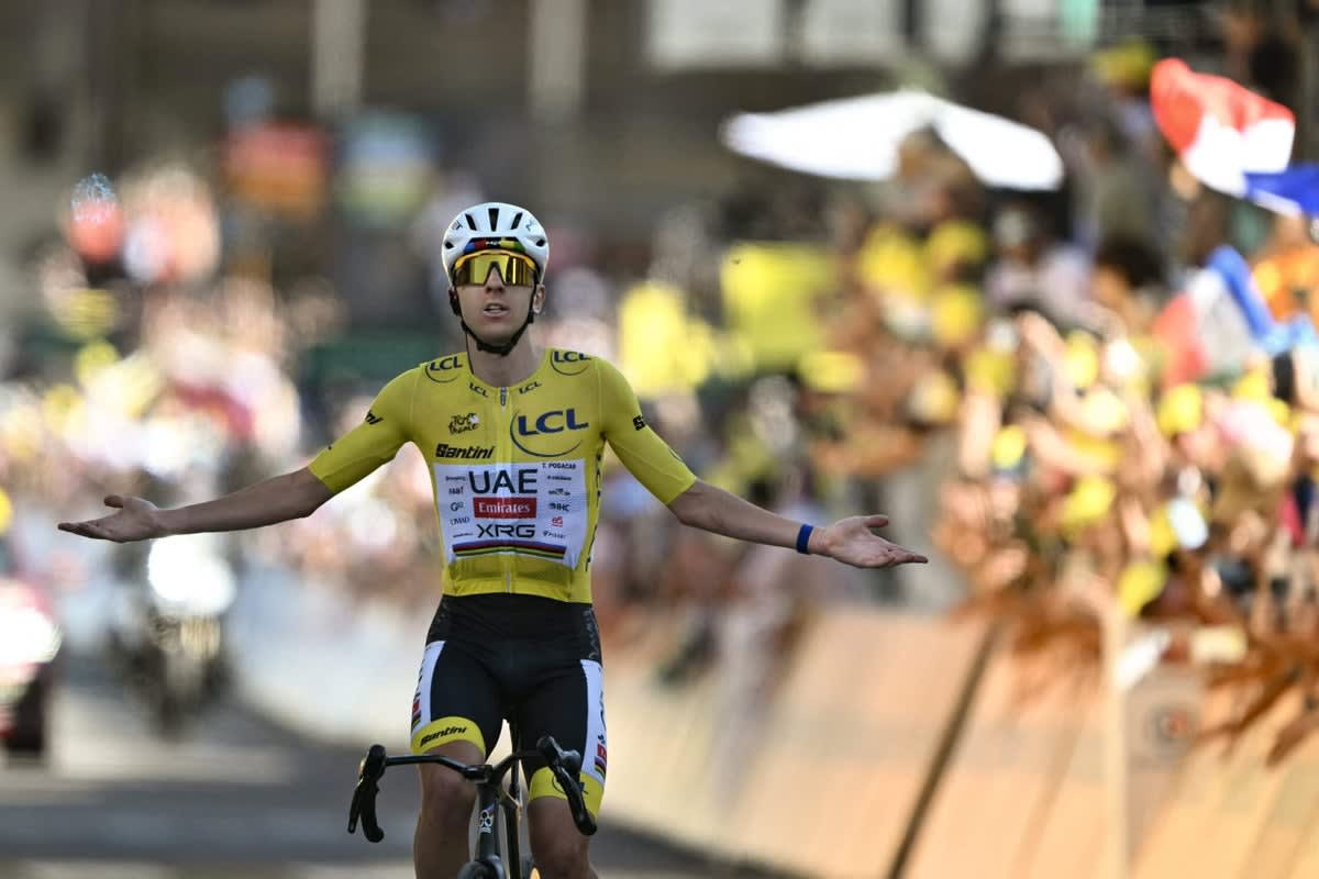 ** Tadej Pogačar celebrating his historic victory while climbing Alpe d'Huez during Tour de France