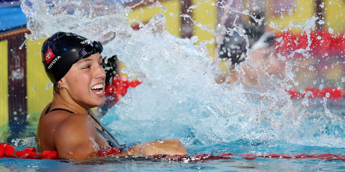 McKenzie Siroky celebrating after winning gold medal at swimming championship pool