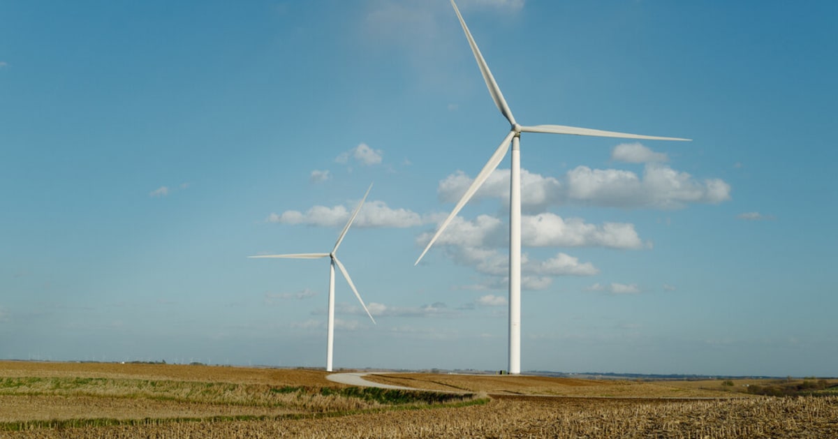 Wind turbines and solar panels generating clean renewable energy on open land
