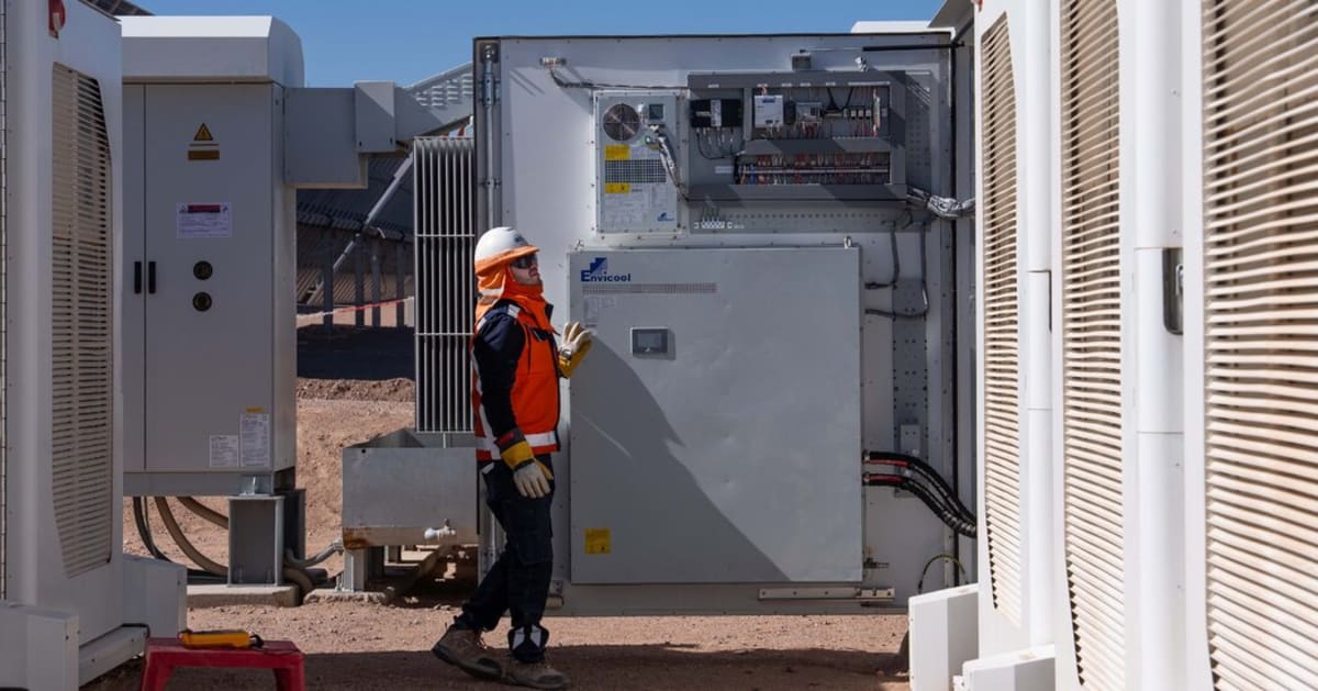 Large solar panel array with battery storage facility under bright blue sky