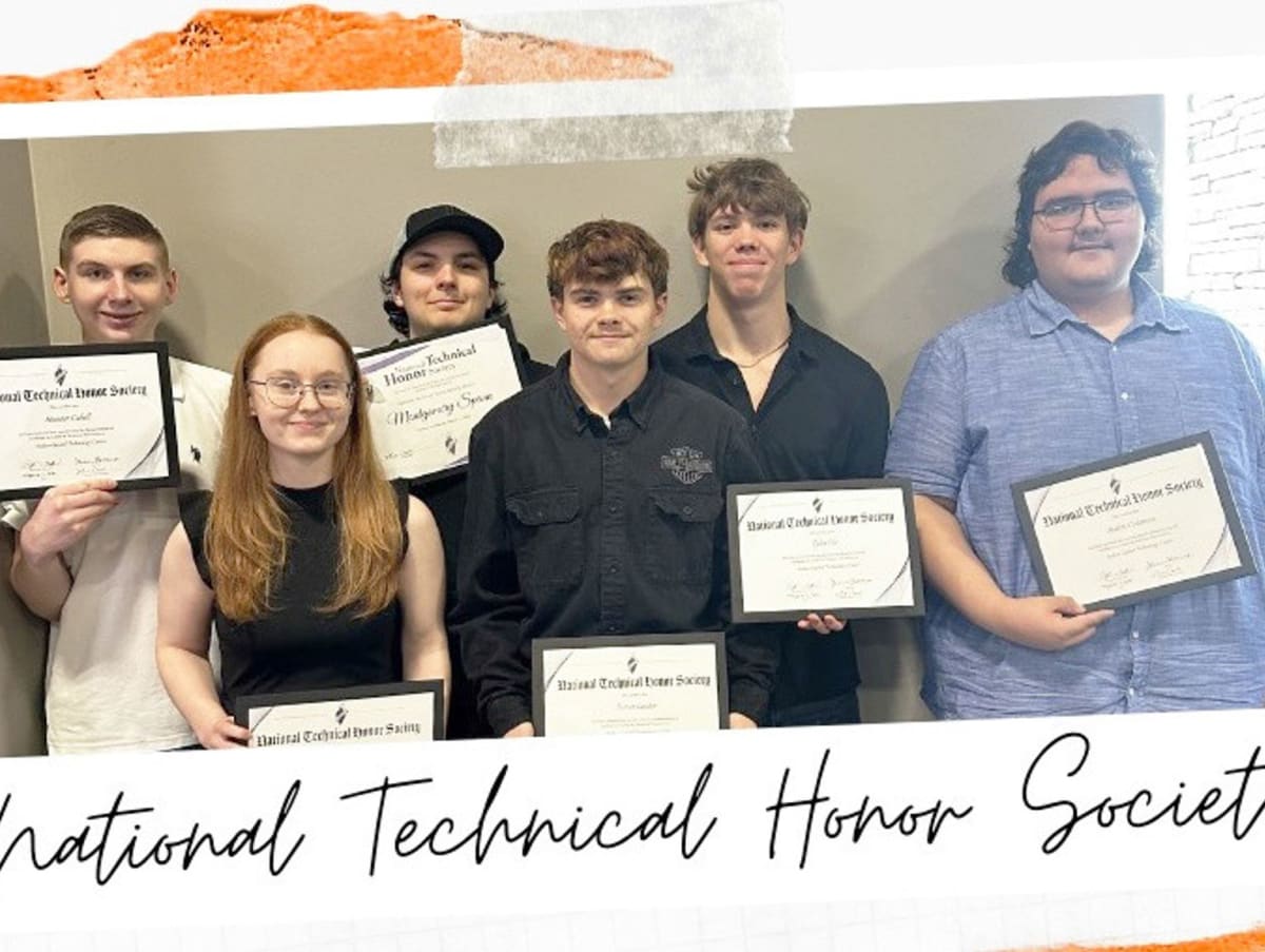 Group of eight high school students in professional attire celebrating technical education honor society induction