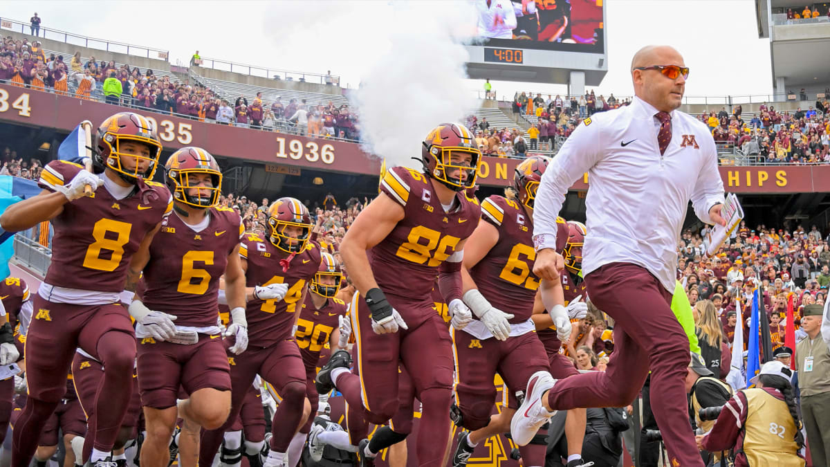 Minnesota Golden Gophers football fans celebrating with synchronized Viking Row gesture at stadium
