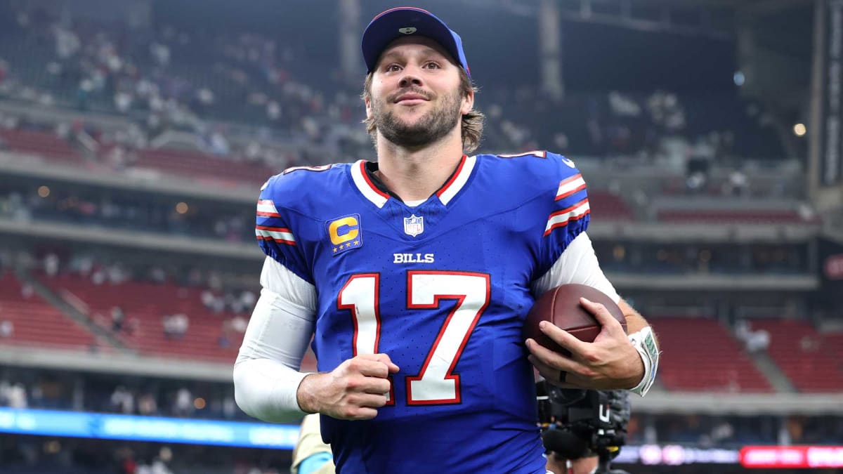 Josh Allen in Buffalo Bills uniform standing on natural grass field at new Highmark Stadium