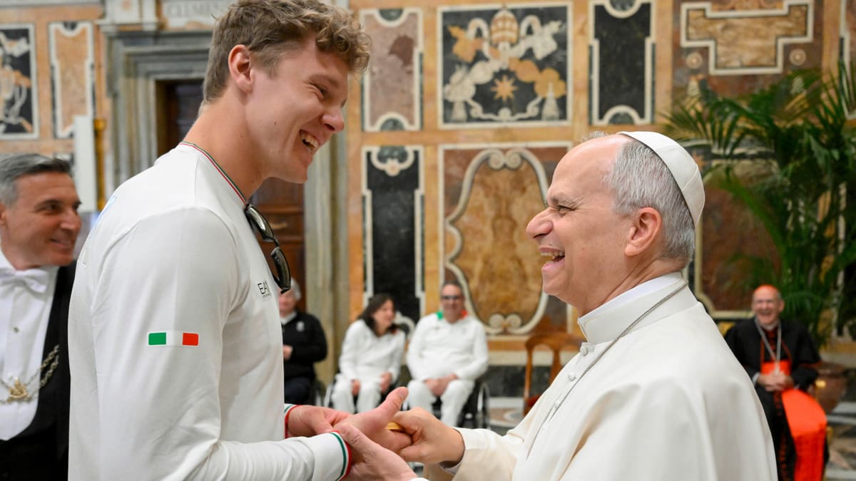Pope Leo smiling while holding Olympic gold medal with Italian skier Simone Deromedis at Vatican audience