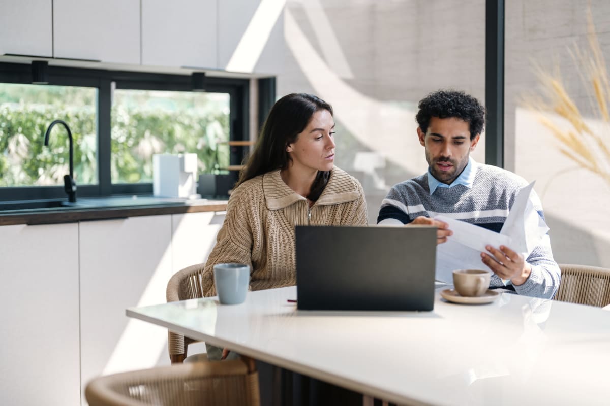 Happy couple sitting together reviewing finances and having a positive conversation about money