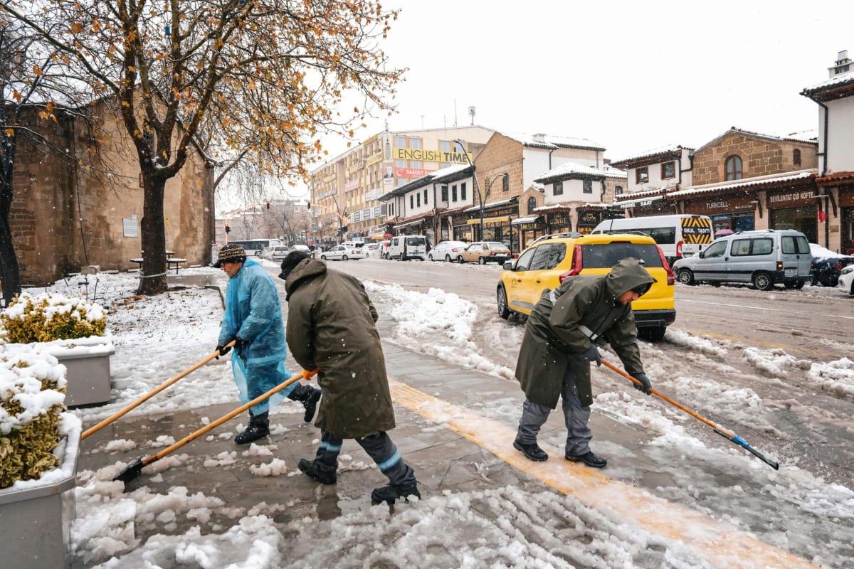 Volunteer shoveling snow from sidewalk to help elderly neighbor in residential Maryland neighborhood