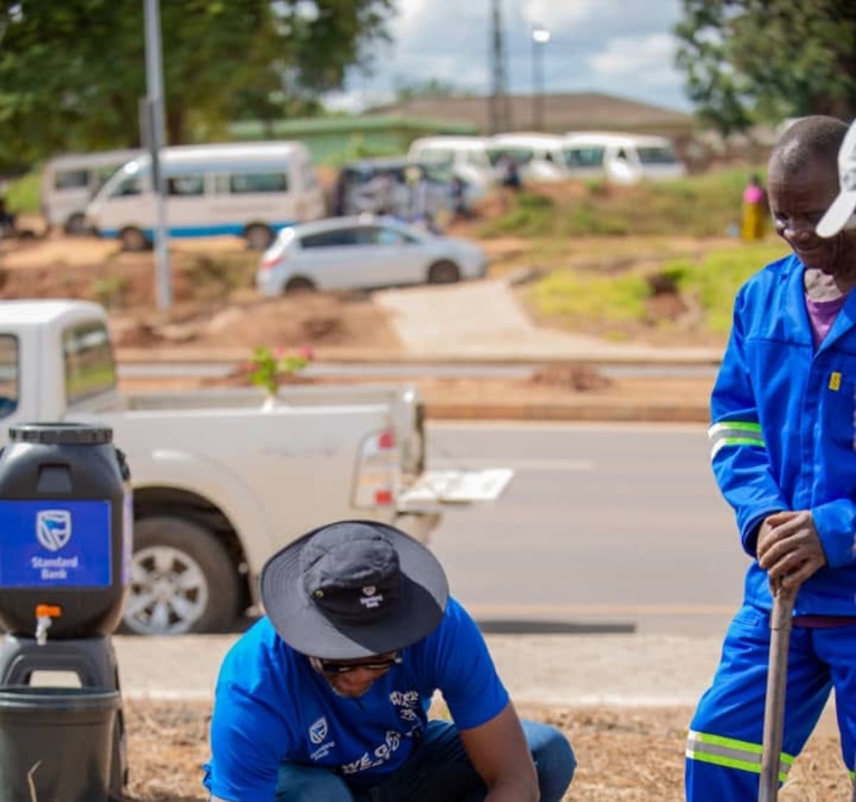 Standard Bank CEO Phillip Madinga watering a newly planted tree seedling in Lilongwe, Malawi