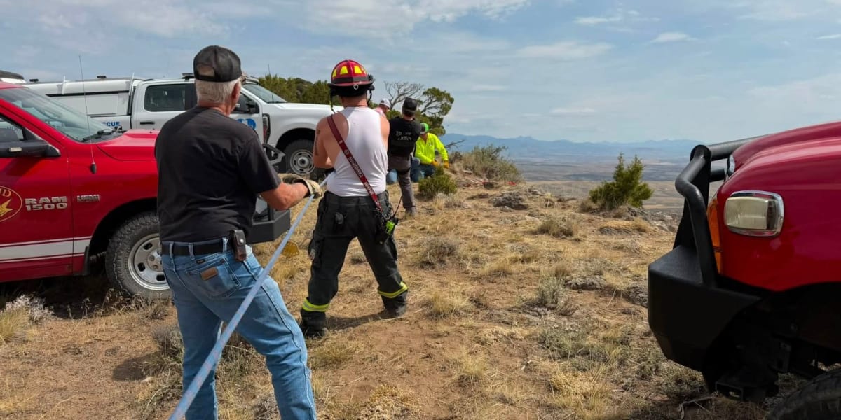 Emergency rescue team performing technical rope operation on steep mountain terrain in Colorado