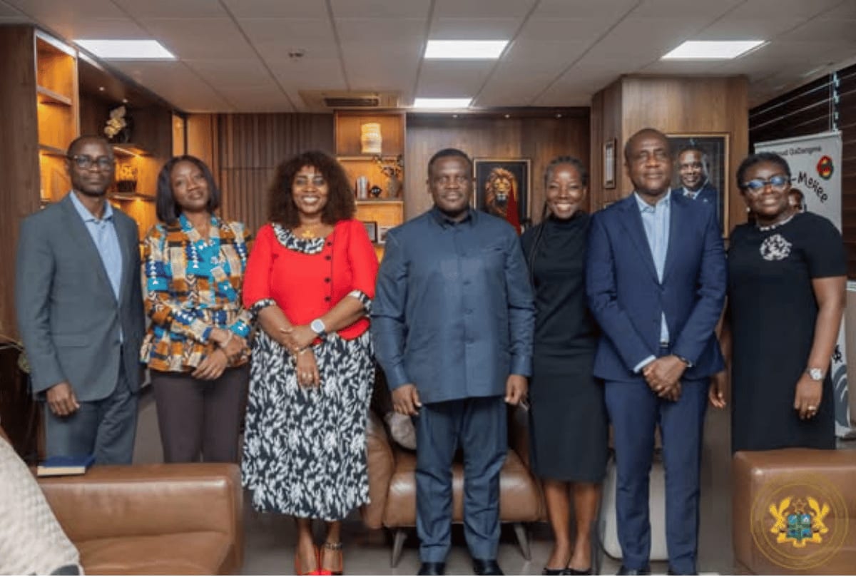 Ghanaian entrepreneurs collaborating on technology projects with laptop computers in modern office space
