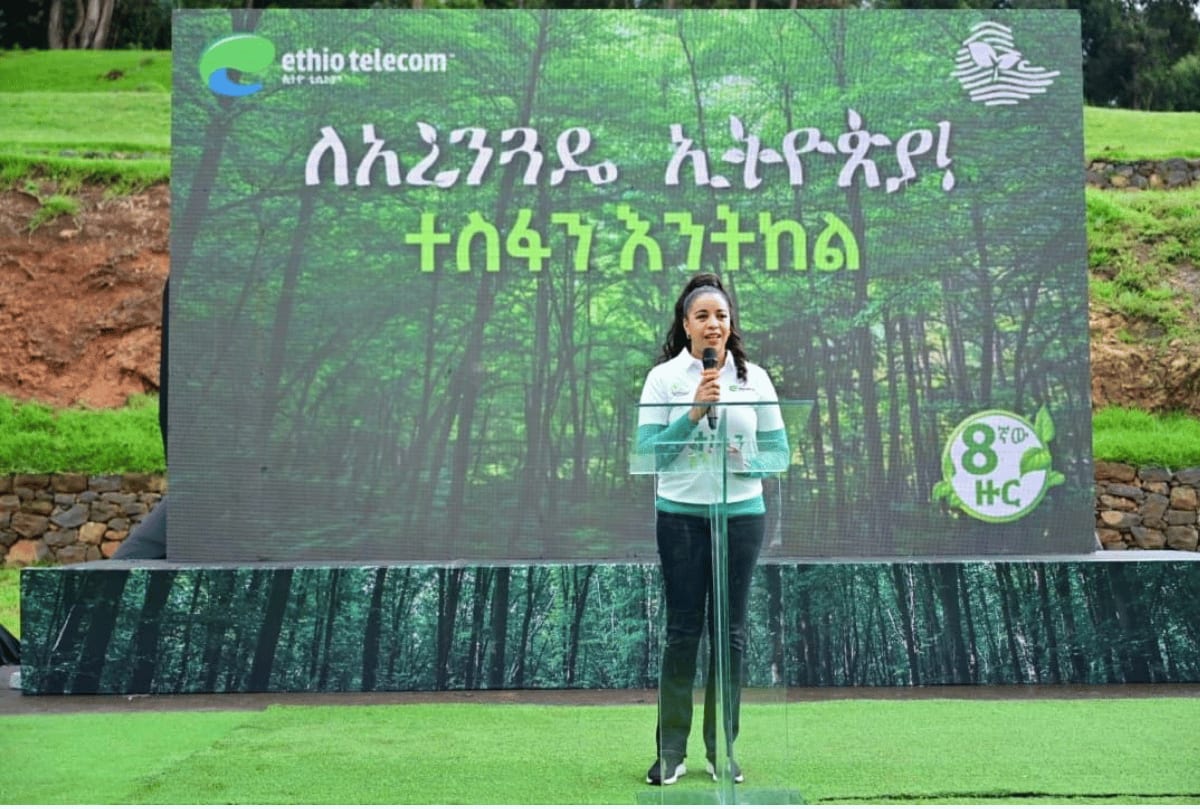 Ethiopian telecom workers planting tree seedlings near solar-powered mobile phone tower in rural Ethiopia