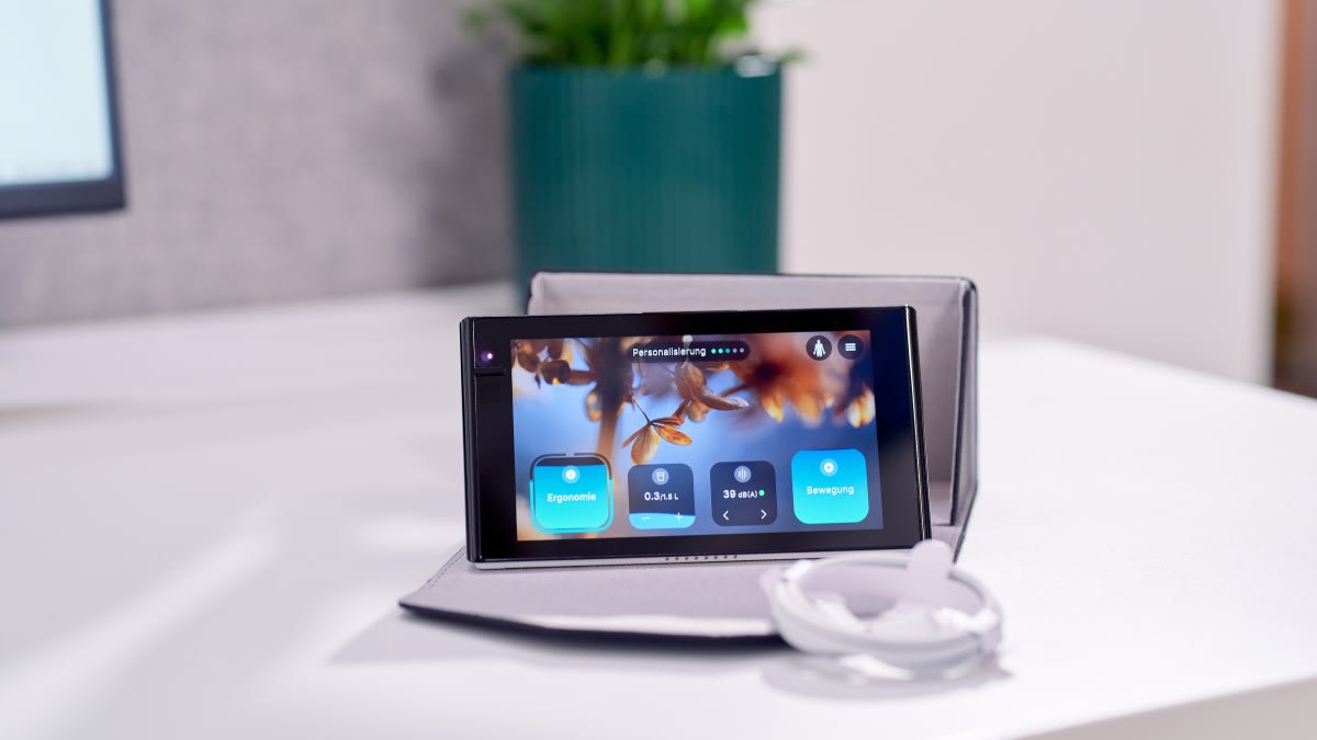 Small desk device with digital display showing posture tracking ring and wellness metrics