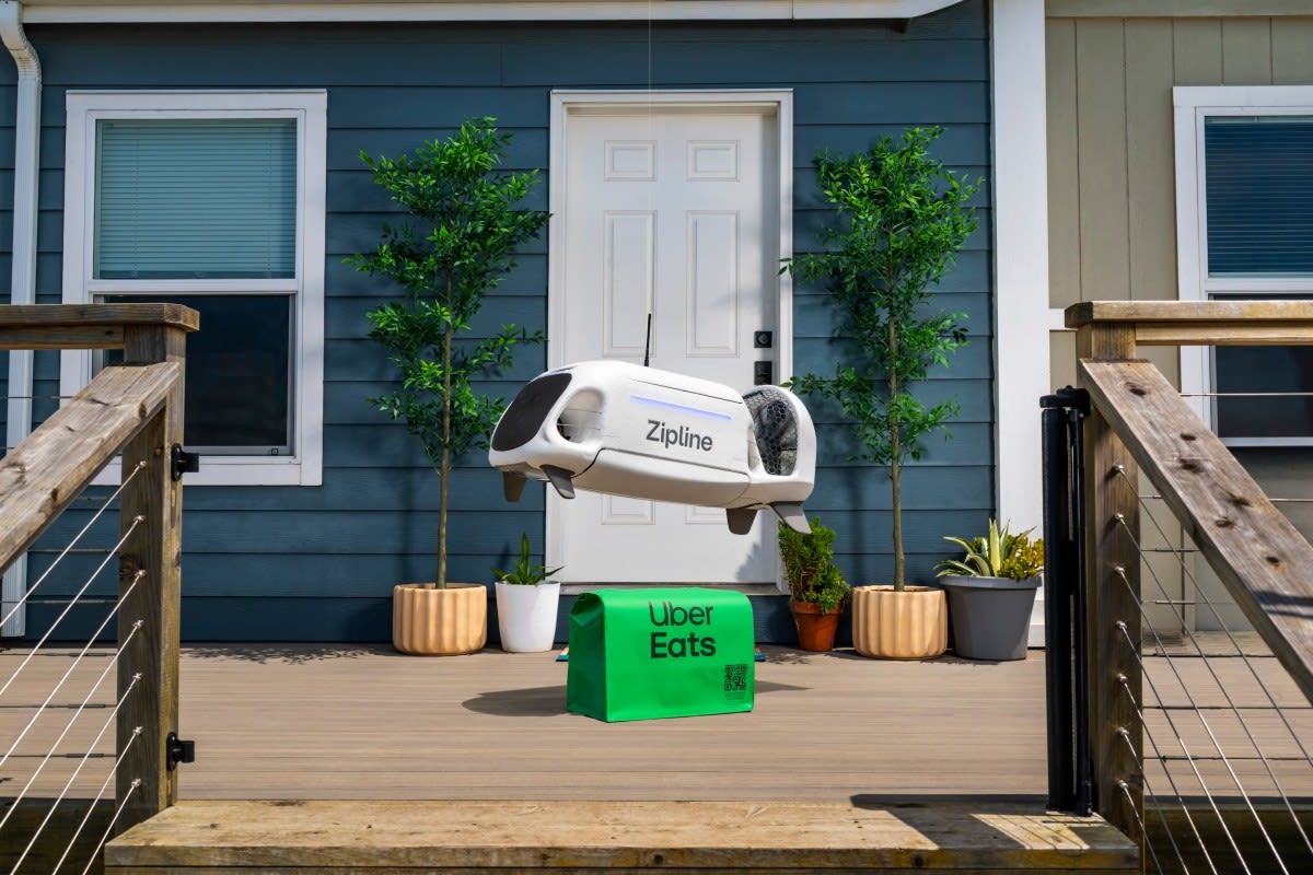 Zipline delivery drone flying over urban area carrying package for Uber Eats customer